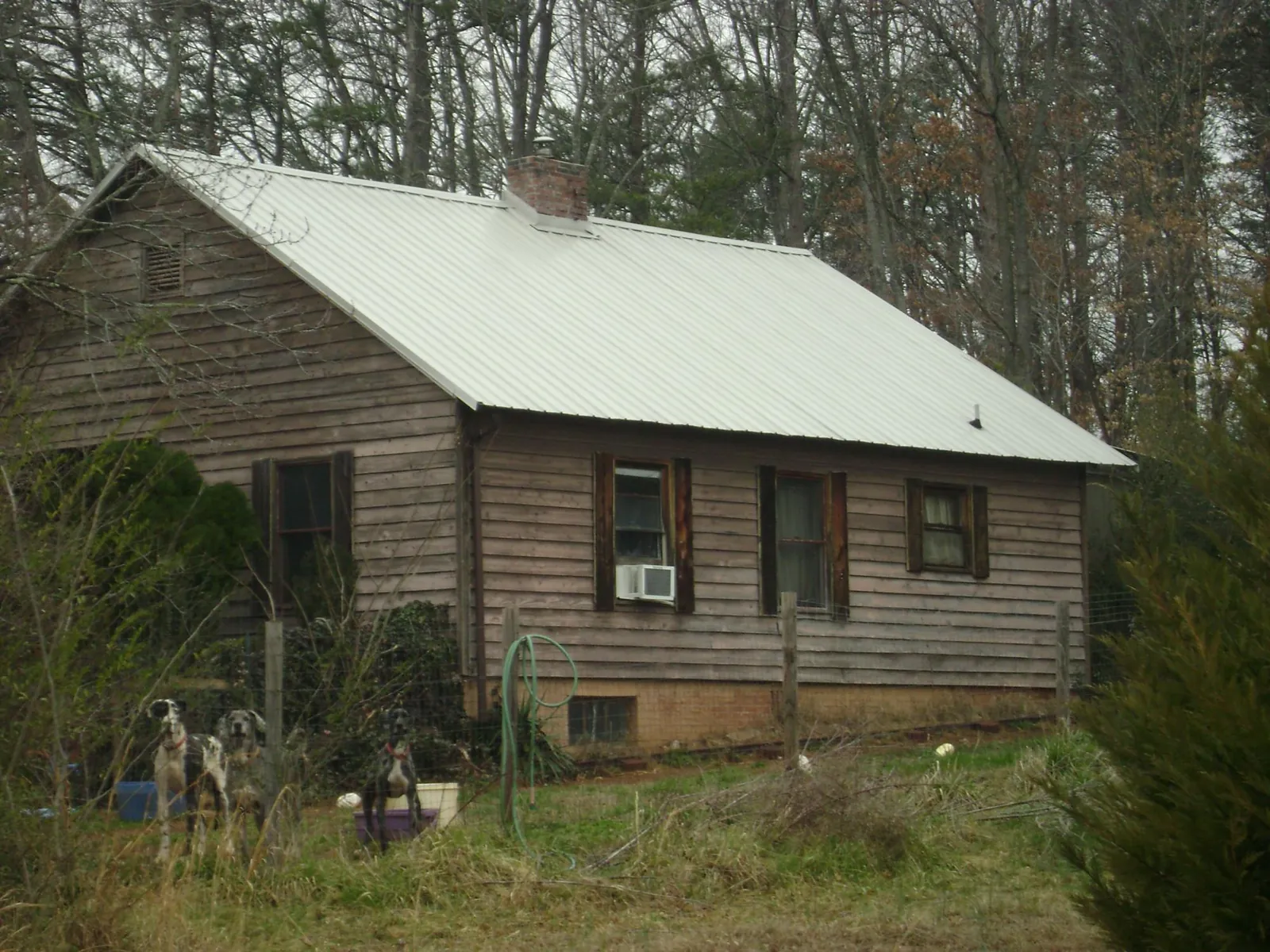 White metal roof on an old wood sided farmhouse, from a Metal Roof Installation job in Thrall